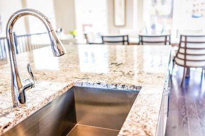 New Modern Faucet and Kitchen Room Sink Closeup With Island and Granite