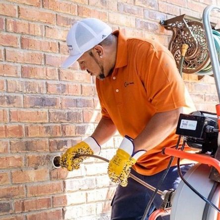 The owner of Made's Plumbing is working on a clogged drain.