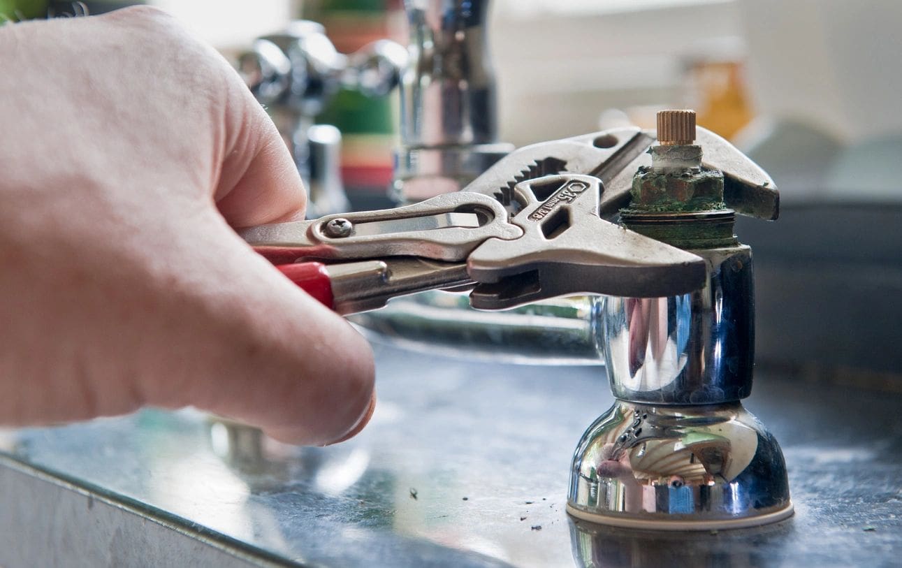 qtq80-ghClu2 Hand using pliers to fix faucet.